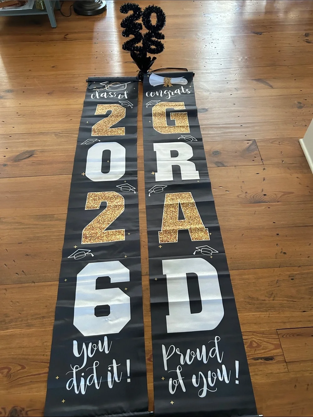Graduation Decor.  Two black and gold banners and one tabletop “2026”.